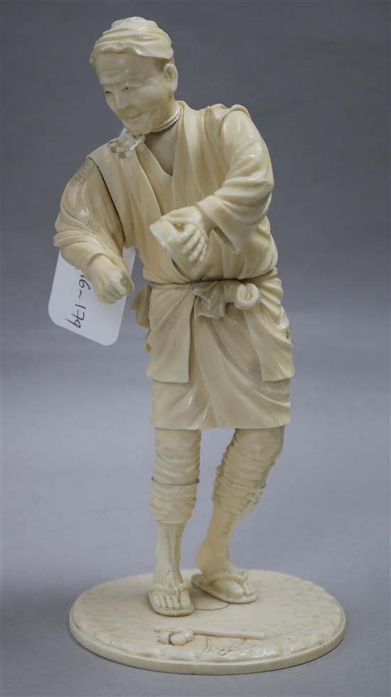 A Japanese sectional ivory figure of a street peddler, Meiji period, 24.5cm